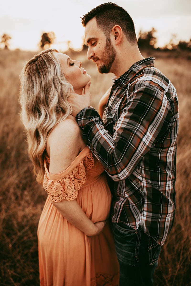 Orlando Family Photographer, couples maternity shoot, manly tilting woman's head up for a kiss