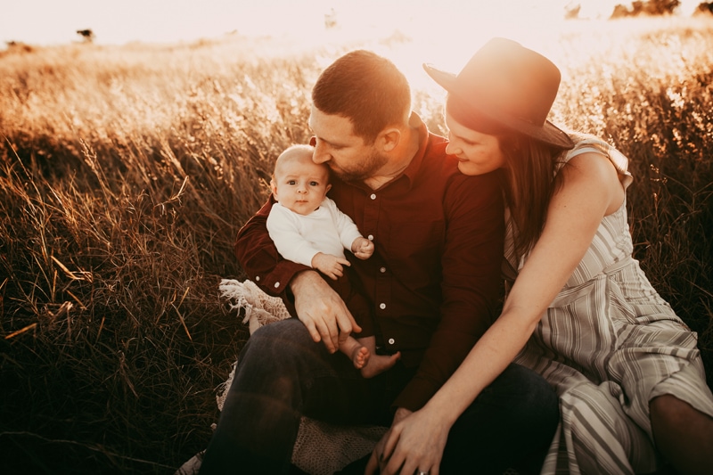 Orlando Family Photography. family of three sitting together in field