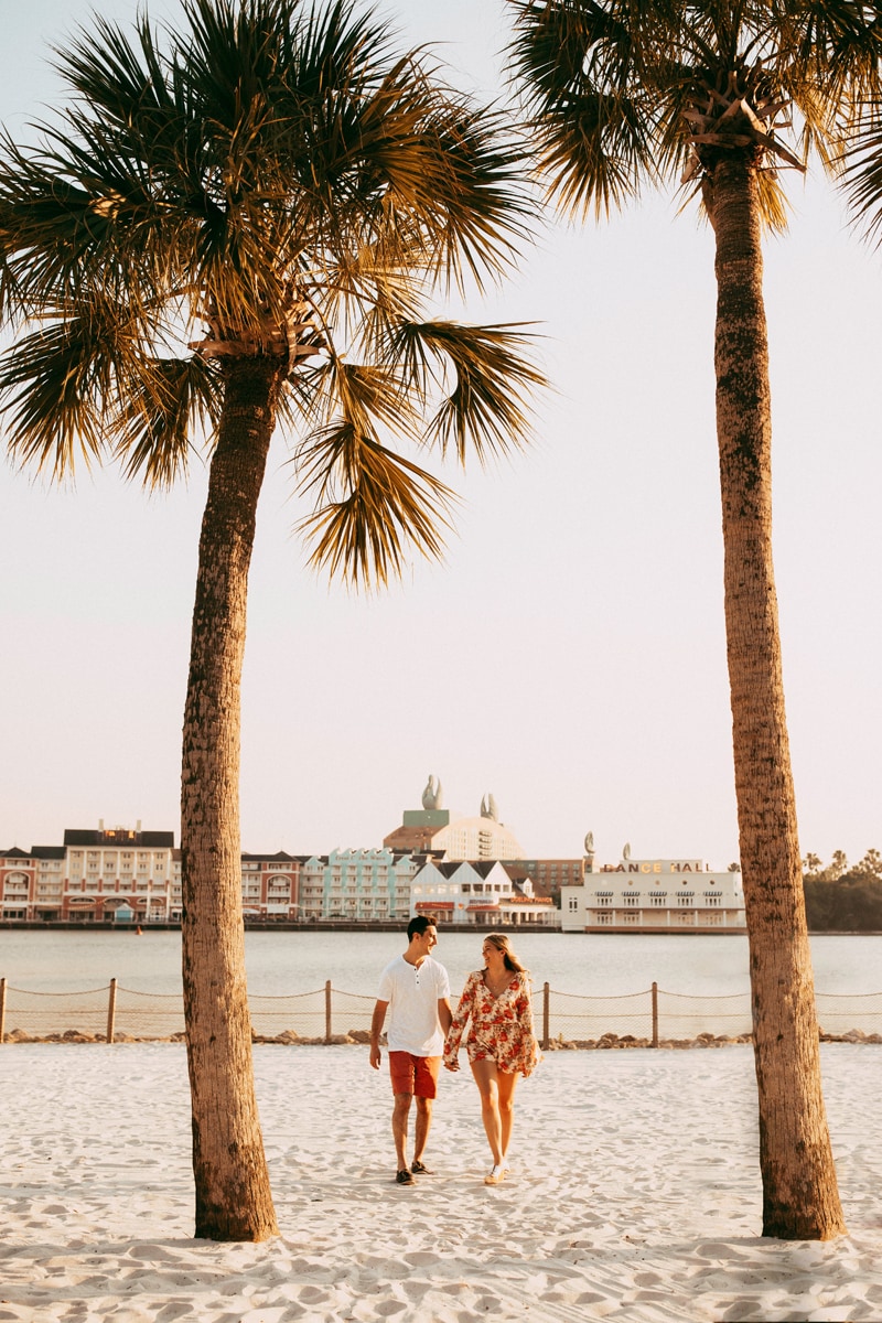 Orlando Couples Photography, wide angle shot of couple walking between two palm trees